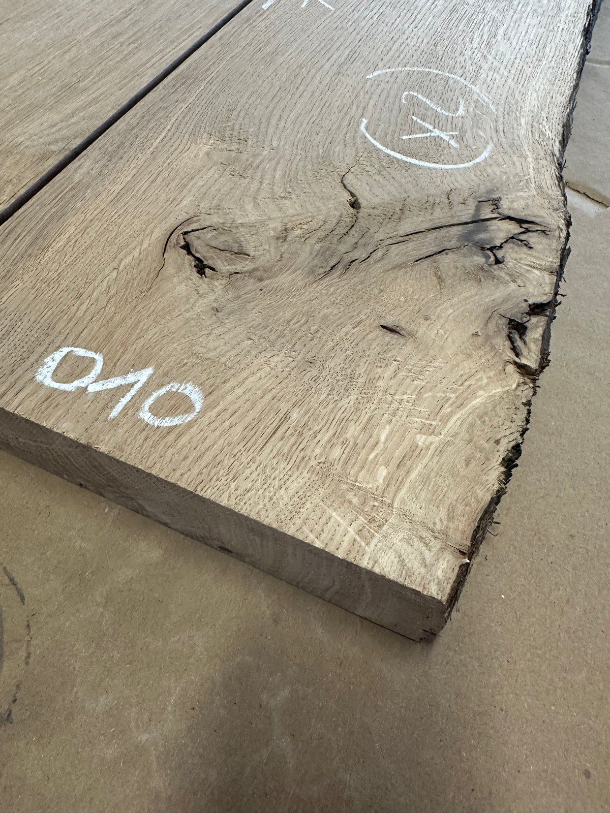 Détail du lot 010 : nœud et cavité visibles sur une étagère en chêne massif.